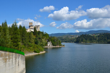 Fototapeta premium Lake Czorsztyn and medieval castle in Niedzica. The beauty of nature and architecture in Southern Poland. Medieval Castle in Niedzica, built in 14th century and artificial Czorsztyn Lake