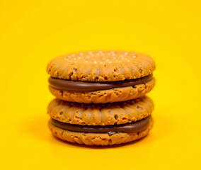 Chocolate Chip Cookies Sandwich with Cream Filling on Yellow Background