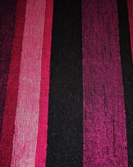 Obraz premium Vertical stripes in pinks and black fabric texture close up textile design background abstract pattern