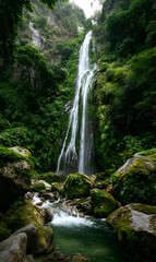 Obraz premium Serene cascade of water descending from a lush green cliffside into a tranquil pool below