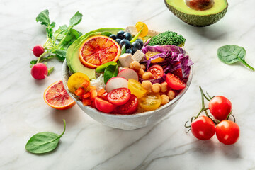 Buddha Bowl. Rainbow salad. Vegan poke bowl with avocado. Fresh and healthy food, with ingredients on a marble table