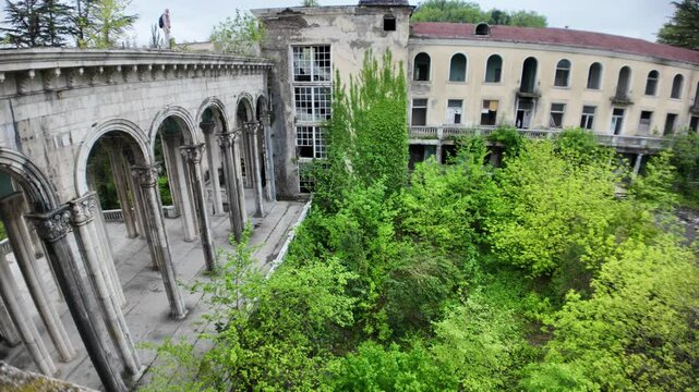 Lush vegetation is slowly taking over the abandoned Sanatorium Medea in Tskaltubo, Georgia, a once popular spa destination during the Soviet era, now a haunting reminder of a bygone time