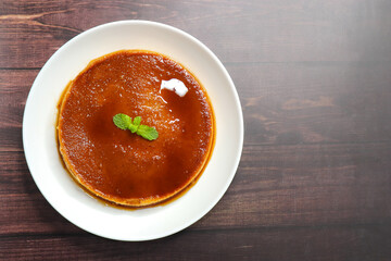 Delicious caramel custard with a glossy caramel top, served on a white plate. Perfectly lit, smooth texture, and minimal background. ideal for menus, blogs, packaging, or dessert features. Copy space