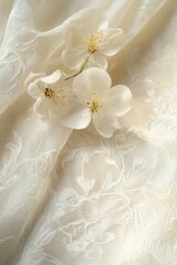 Fototapeta premium Delicate White Blossom Arrangement on Embroidered Fabric Soft Light Close Up Studio Shot
