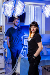 Surgeons in the OR. Two healthcare workers stand confidently in a modern operating room equipped...