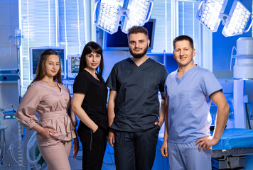 Medical team poses together in hospital. A group of four healthcare professionals stands...
