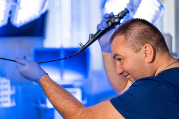 Pro performs procedure in OR. A healthcare professional holds a tool in a bright surgical room,...