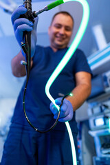 Doctor shows endoscopy tools. A medical professional in blue scrubs skillfully handles endoscopy...