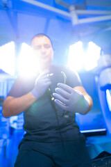 Doc shows surgical tool. A medical professional holds a surgical tool while in a bright operating...