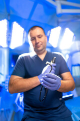 Surgeon sets up tools. A medical professional wearing gloves holds surgical tools in a bright...