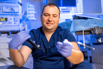Doctor showing medical gear. A medical professional in blue scrubs examines surgical instruments in...