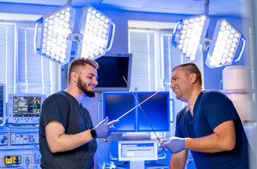 Surgeons sparring indoors. Two surgeons playfully imitate sword fighting with surgical tools in a...