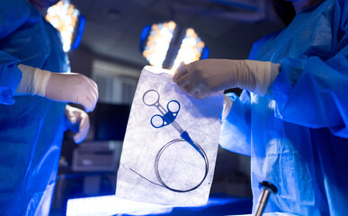 Surgery in a modern OR. Medical professionals prepare surgical instruments in a well-lit operating...