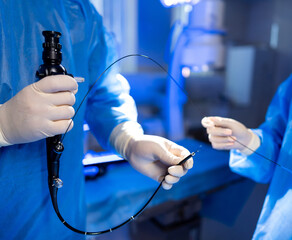 Endoscopy procedure with medical team. Two medical professionals prepare specialized equipment for an endoscopy procedure in a clinical setting.