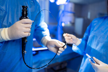 Team gears up for endoscopy. Medical professionals in blue scrubs ready equipment for an endoscopy...