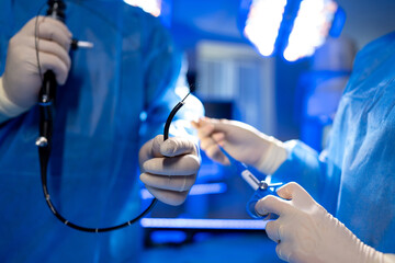 Laparoscopic surgery in action. Blue-scrubbed medics use tools in a high-tech room for a...