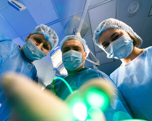Surgeons ready for surgery. Medical professionals in surgical attire focus on a procedure in an...