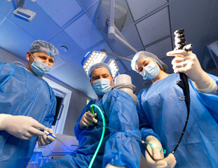 Endoscopic procedure by team. Surgeons in surgical gear conduct an endoscopic procedure with...