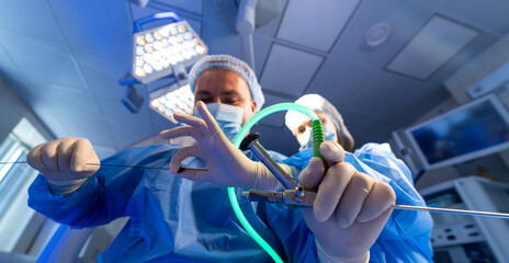 Surgeons in intricate operation. Two surgeons in surgical attire conduct a delicate medical...