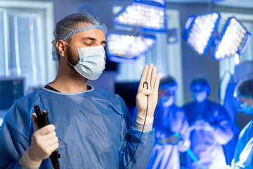 Surgeon ready in OR. A surgeon stands ready in a well-lit operating room, focusing on the surgical...
