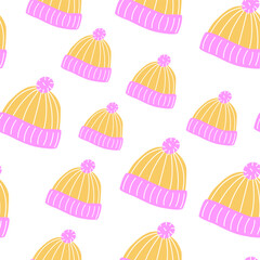 Seamless yellow and pink knit hat pattern with pom-poms for fabrics and seasonal decoration