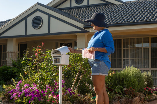 Woman Checking Mail in Front Yard of Australian Home