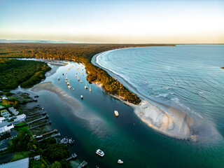 Coastal aerial view showcasing river and lush greenery in Jervis Bay