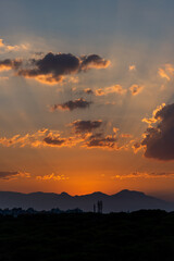 Scenic view of a vibrant sunset over mountains, airplane flying across the colorful sky.