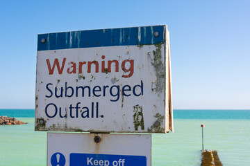 warning submerged outfall sign by the coast