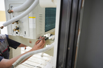 Air conditioning technicians install new air conditioners in homes, Repairman fix air conditioning systems, Male technician service for repair and maintenance of air conditioners