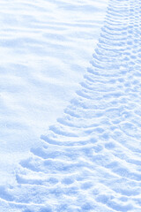 Tractor clear trail tracks in snow blue tone sunny day