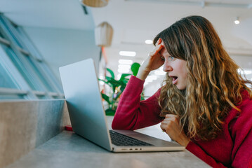 Shocked woman staring at high flight prices on laptop while searching for summer vacation options...