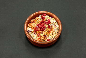 A wonderful cabbage salad with pomegranate seeds in a terracotta container