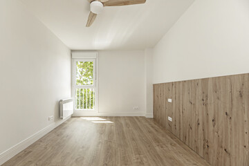 A newly renovated unfurnished room with wooden floors and walls