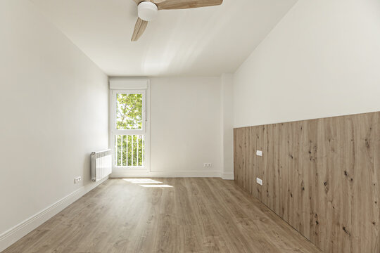 A newly renovated unfurnished room with wooden floors and walls