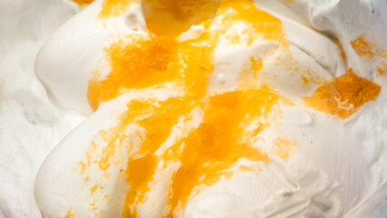 Abstract swirls of white with orange highlights create a textural delight of yogurt