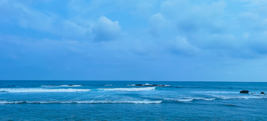 Obraz premium Atmospheric oceanic view with waves crashing against distant coastal rocks