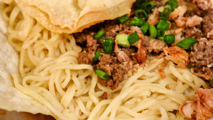 Authentic Noodle Dish with Savory Toppings and Crispy Wonton Presentation