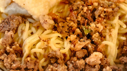 Close-up of savory noodles dish with meat topping, a flavorful culinary experience