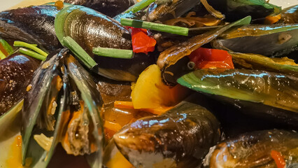 Delicious Cooked Mussels with Colorful Vegetables and savory spices for a gourmet seafood cuisine