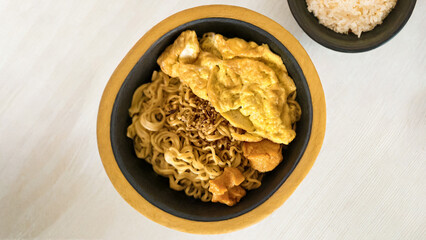 Delicious noodle dish with egg omelet served in a rustic wooden bowl