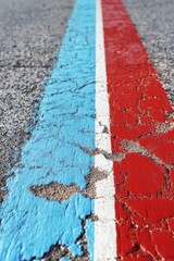 Asphalt road markings close up of blue white and red lines on cracked surface ground level perspective