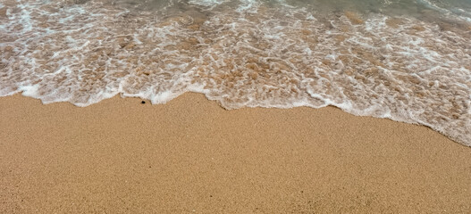 Gentle waves lapping on golden sand creating a serene beach scenery
