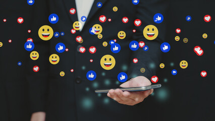 Businessman using smartphone with social media reaction icons floating. Concept of digital...