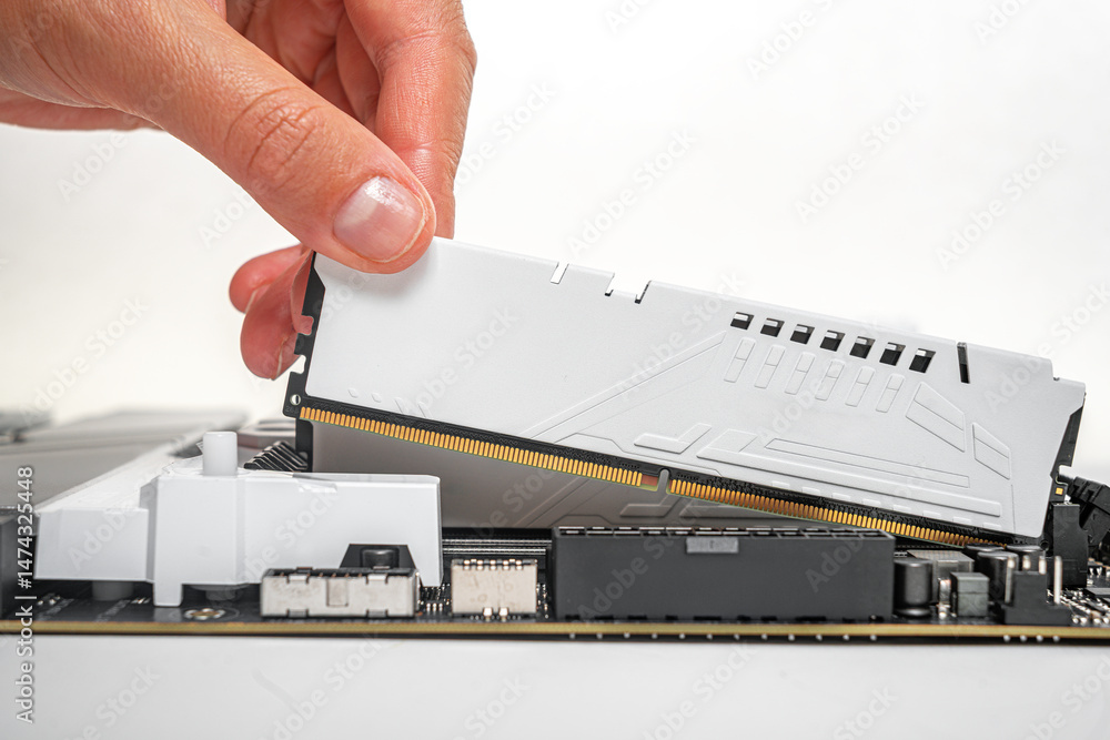 Poster a person is carefully inserting a white ddr ram module into a motherboard slot during a desktop comp