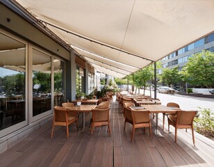 Fototapeta premium modern outdoor restaurant seating with wooden tables and chairs under a white awning adjacent to a building with large glass windows during daytime