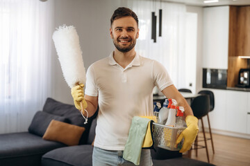 Positive facial expression. Male professional cleaning service worker is domestic room