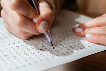 Fototapeta na wymiar Close Up of Woman Filling in Standardized Test Answer Sheet