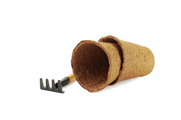 Peat pots for seedlings and a rake. Isolated on white background.