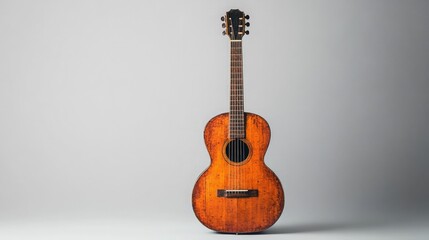 Clean studio shot of an acoustic guitar against a seamless gray background
